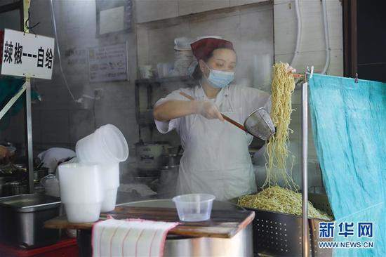 4月22日，武漢市糧道街的家陽“趙師傅”天天紅油熱干面店廚師在制作熱干面。新華社記者 沈伯韓 攝