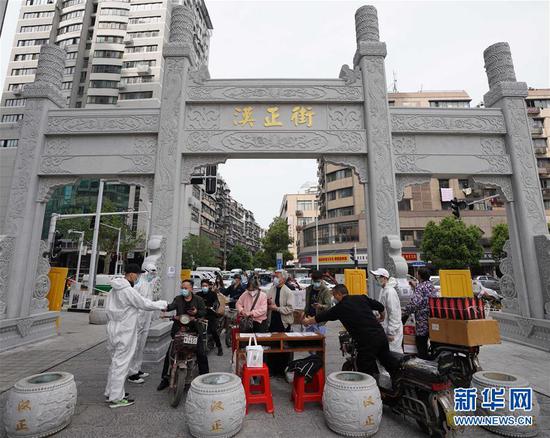  4月16日，進(jìn)出武漢漢正街步行街的人員在掃描健康碼。新華社記者 王毓國 攝